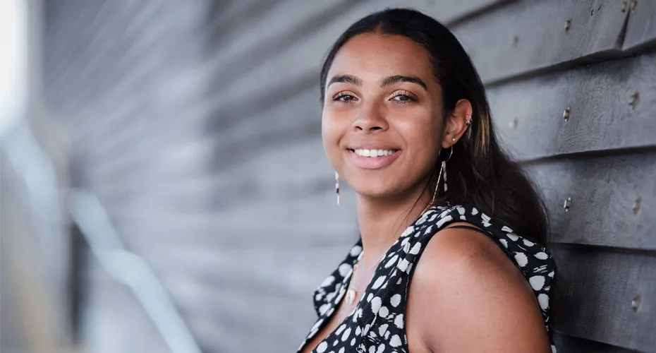A smiling undergraduate business student wearing a black and white polka dot dress.
